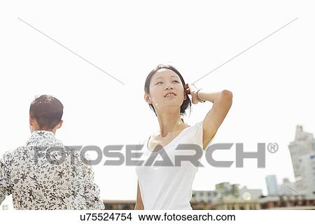Picture - "Young female tourist looking over her shoulder, The Bund, Shanghai, China". Fotosearch