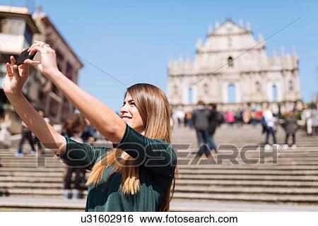 "Young female tourist taking smartphone selfie in front of St Pauls Cathedral ruins, Macau, Hong Kong, China" View Large Photo Image Stock Photograph - "Young female tourist taking smartphone selfie in front of St Pauls Cathedral ruins, Macau, Hong Kong, China". Fotosearch