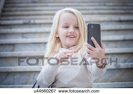 "Young girl on stairway taking smartphone selfie, Cagliari, Sardinia, Italy" View Large Photo Image Stock Photo - "Young girl on stairway taking smartphone selfie, Cagliari, Sardinia, Italy". Fotosearch