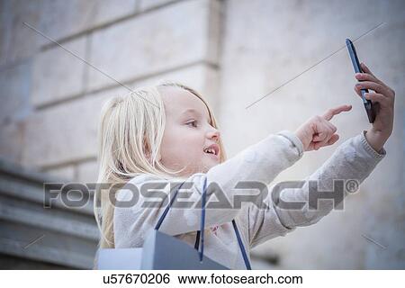 "Young girl on stairway using touchscreen on smartphone, Cagliari, Sardinia, Italy" View Large Photo Image Stock Photograph - "Young girl on stairway using touchscreen on smartphone, Cagliari, Sardinia, Italy". Fotosearch