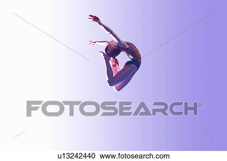 Stock Image - Young gymnast in mid-air leap. Fotosearch