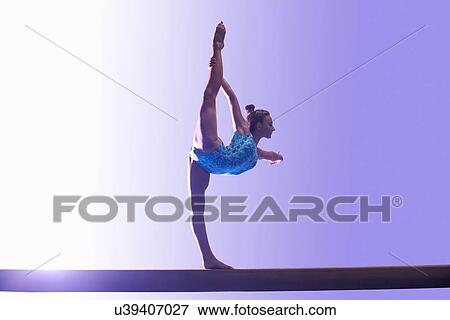 Stock Photo - Young gymnast performing on balance beam. Fotosearch