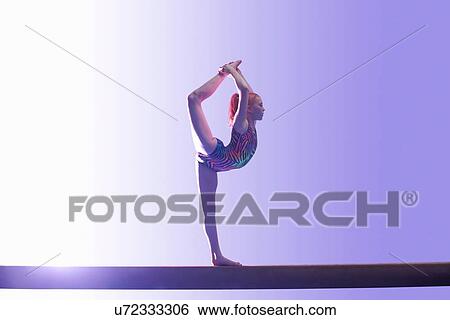 Young gymnast performing on balance beam View Large Photo Image Stock Photograph - Young gymnast performing on balance beam. Fotosearch