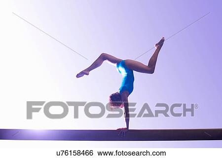 Young gymnast performing on balance beam View Large Photo Image Stock Photograph - Young gymnast performing on balance beam. Fotosearch