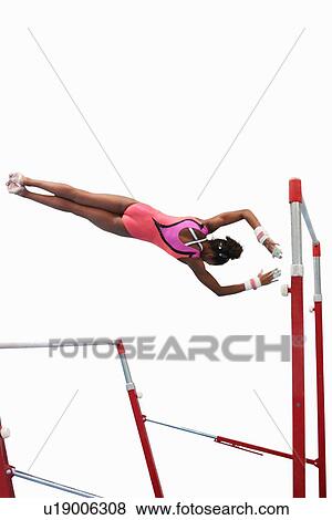 Young gymnast performing on uneven bars View Large Photo Image Stock Photo - Young gymnast performing on uneven bars. Fotosearch