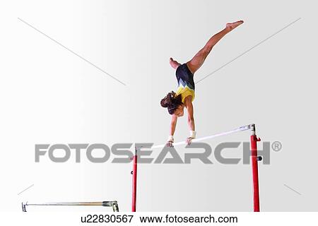 Young gymnast performing on uneven bars View Large Photo Image Stock Photo - Young gymnast performing on uneven bars. Fotosearch