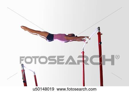 Young gymnast performing on uneven bars View Large Photo Image Stock Photo - Young gymnast performing on uneven bars. Fotosearch