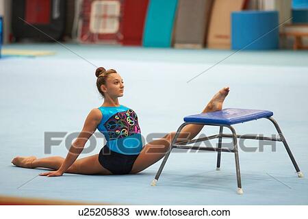 Stock Image - Young gymnast practising moves. Fotosearch