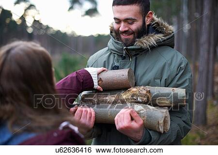 Young hiking couple collecting logs for campfire in forest View Large Photo Image Stock Photograph - Young hiking couple collecting logs for campfire in forest. Fotosearch