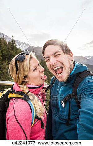 "Young hiking couple posing for selfie in mountains, Reutte, Tyrol, Austria" View Large Photo Image Stock Photo - "Young hiking couple posing for selfie in mountains, Reutte, Tyrol, Austria". Fotosearch