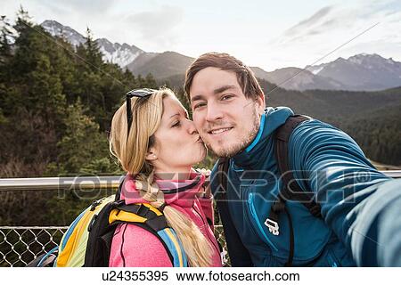 "Young hiking couple taking selfie in mountains, Reutte, Tyrol, Austria" View Large Photo Image Stock Photography - "Young hiking couple taking selfie in mountains, Reutte, Tyrol, Austria". Fotosearch
