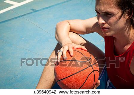 Young male basketball player sitting on basketball court View Large Photo Image Stock Image - Young male basketball player sitting on basketball court. Fotosearch