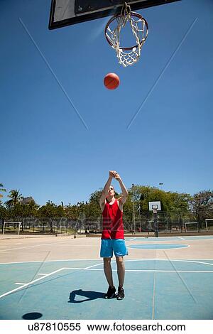 Young male basketball player throwing ball toward basketball hoop View Large Photo Image Stock Photography - Young male basketball player throwing ball toward basketball hoop. Fotosearch