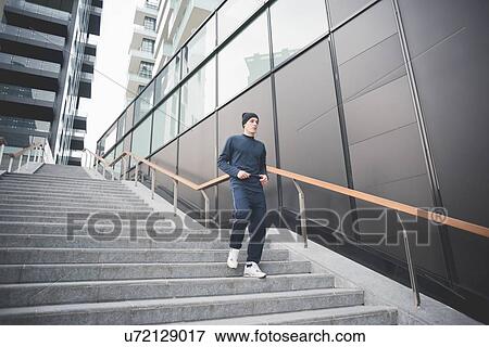 Stock Photo - Young male runner moving down city stairs. Fotosearch