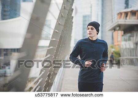 Young male runner on city footbridge View Large Photo Image Stock Photo - Young male runner on city footbridge. Fotosearch