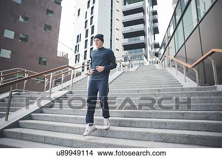 Picture - Young male runner running down city stairs. Fotosearch