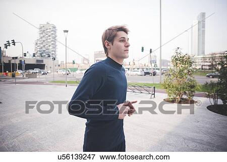 Young male runner running in city square View Large Photo Image Stock Photo - Young male runner running in city square. Fotosearch