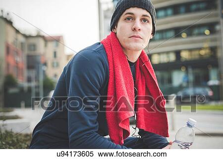 Young male runner taking a break in city View Large Photo Image Stock Photography - Young male runner taking a break in city. Fotosearch