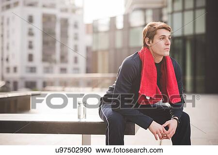 Young male runner taking a break on bench in city square View Large Photo Image Stock Image - Young male runner taking a break on bench in city square. Fotosearch