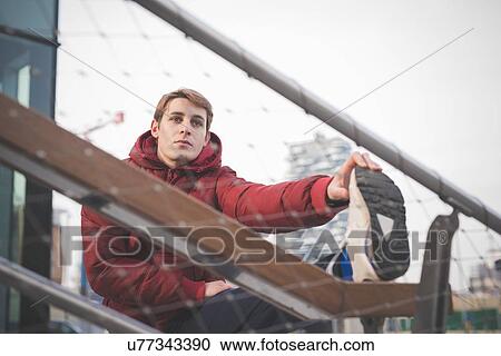 Young male runner touching toes on city stairs View Large Photo Image Stock Image - Young male runner touching toes on city stairs. Fotosearch