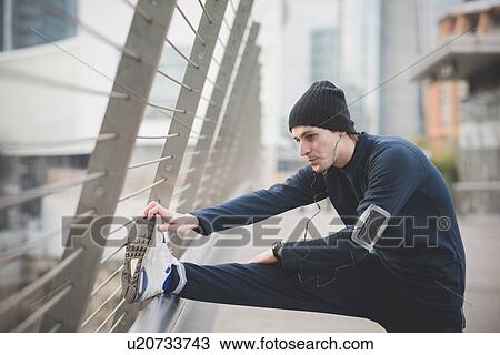 Young male runner warming up on city footbridge View Large Photo Image Stock Image - Young male runner warming up on city footbridge. Fotosearch
