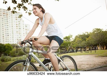 Young man cycling in park View Large Photo Image Picture - Young man cycling in park. Fotosearch