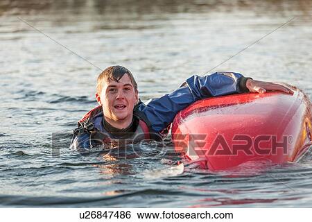 Stock Photograph - Young man falling in water with kayak. Fotosearch