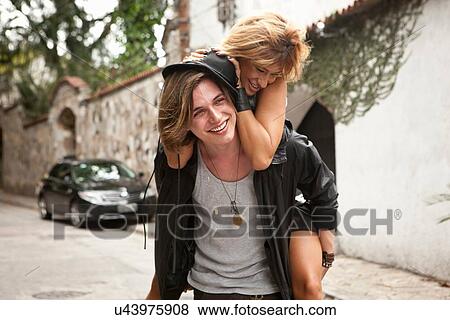 "Young man giving girlfriend a piggyback on street, Rio De Janeiro, Brazil" View Large Photo Image Stock Photo - "Young man giving girlfriend a piggyback on street, Rio De Janeiro, Brazil". Fotosearch