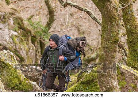 Young man hiking through forest with backpack View Large Photo Image Stock Photo - Young man hiking through forest with backpack. Fotosearch