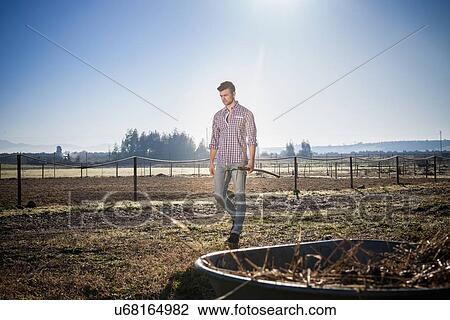 Stock Image - Young man in field. Fotosearch