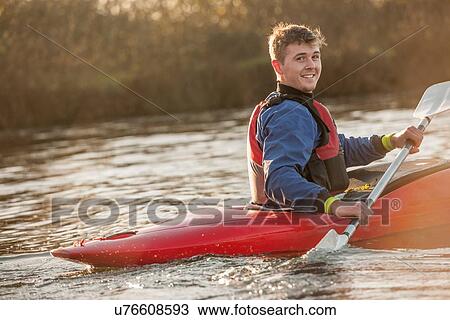 Stock Image - Young man in kayak. Fotosearch