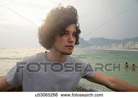 Stock Photograph - "Young man on breezy Ipanema beach, Rio De Janeiro, Brazil". Fotosearch