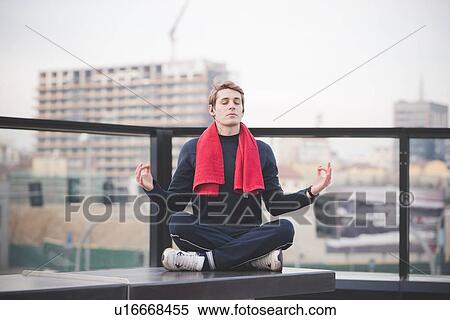 Young man practicing lotus yoga position on city rooftop View Large Photo Image Stock Photography - Young man practicing lotus yoga position on city rooftop. Fotosearch