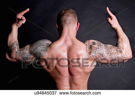 Stock Photo - Young man showing rear double biceps. Fotosearch