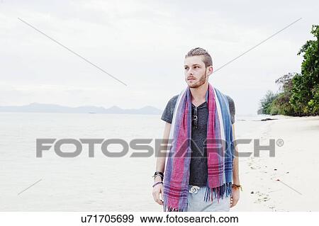 Stock Photo - "Young man strolling on beach, Kradan, Thailand". Fotosearch