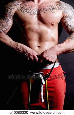 Young man using resistance band View Large Photo Image Stock Image - Young man using resistance band. Fotosearch