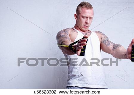 Young man using resistance bands View Large Photo Image Stock Image - Young man using resistance bands. Fotosearch