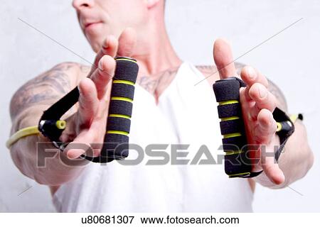 Stock Photo - "Young man using resistance bands, close up". Fotosearch
