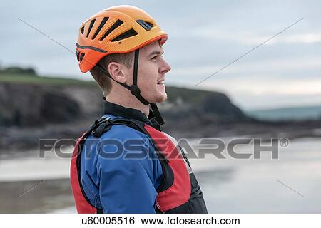 Stock Photograph - Young man wearing helmet and life jacket. Fotosearch