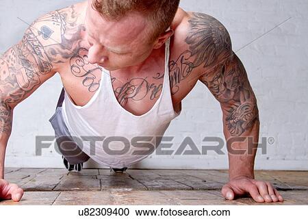Young man with tattoos doing press ups View Large Photo Image Stock Image - Young man with tattoos doing press ups. Fotosearch