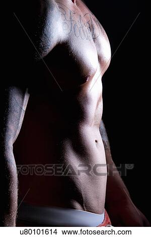 Picture - "Young mans torso, side lit". Fotosearch