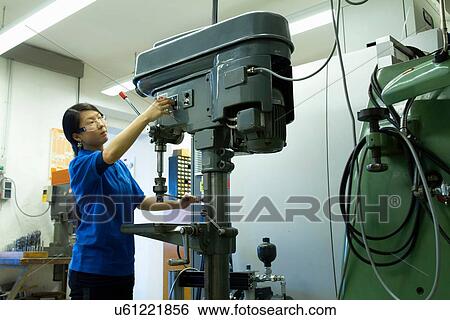 Young woman adjusting drill in industrial workshop View Large Photo Image Stock Photograph - Young woman adjusting drill in industrial workshop. Fotosearch