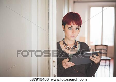 Young woman at home using digital tablet View Large Photo Image Stock Image - Young woman at home using digital tablet. Fotosearch