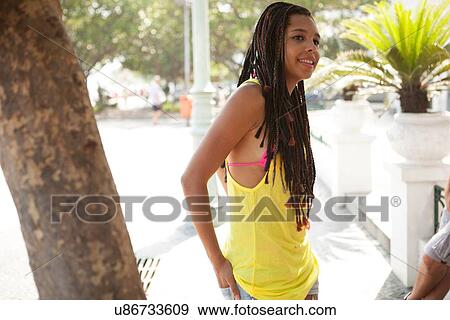 Stock Photo - "Young woman chatting on sidewalk, Copacabana, Rio De Janeiro, Brazil". Fotosearch