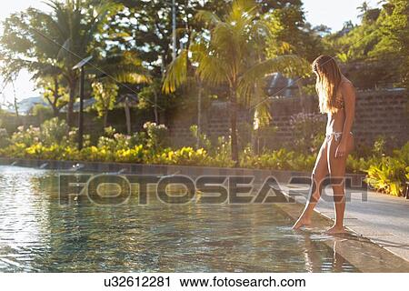 Stock Image - "Young woman dipping toes into pool, Panay Island, Visayas, Philippines". Fotosearch