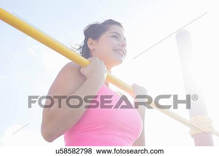 Young woman doing chin ups on exercise bar View Large Photo Image Stock Photo - Young woman doing chin ups on exercise bar. Fotosearch