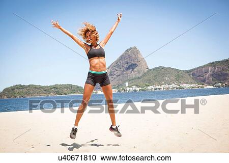 "Young woman doing star jump on beach, Rio de Janeiro, Brazil" View Large Photo Image Stock Image - "Young woman doing star jump on beach, Rio de Janeiro, Brazil". Fotosearch