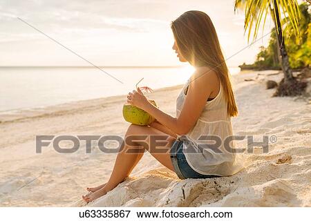 "Young woman drinking coconut milk on Anda beach, Bohol Province, Philippines" View Large Photo Image Stock Photo - "Young woman drinking coconut milk on Anda beach, Bohol Province, Philippines". Fotosearch