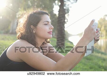 Stock Image - Young woman enjoying park. Fotosearch