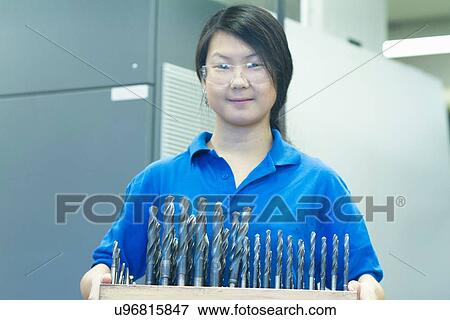 Young woman holding drill bits View Large Photo Image Stock Photo - Young woman holding drill bits. Fotosearch